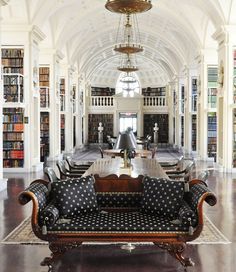 the library is full of books and people sitting at tables