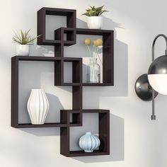 a wall mounted shelf with vases and plants on it