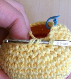 a crocheted object being worked on by someone using a pair of knitting scissors