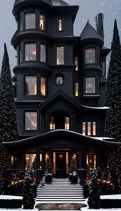 a large black house with lots of windows and christmas lights on it's side