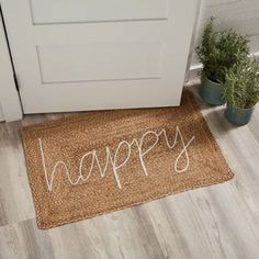 a door mat that says happy next to a potted plant