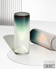 a white table with a black and green cylinder next to it on top of the table