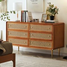 a wooden dresser with wicker drawers in a living room