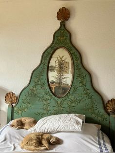 a dog laying on top of a bed next to a mirror above it's head