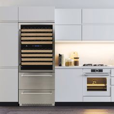 a modern kitchen with white cabinets and stainless steel appliances, including a wine cooler in the middle