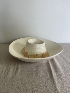 a white plate with a brown and green design on the rim sitting on a table