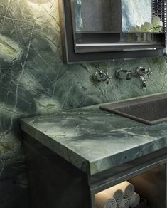 a bathroom sink sitting under a mirror next to a counter