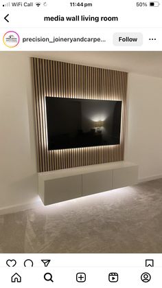 a room with a large television mounted on the wall and some lights in front of it