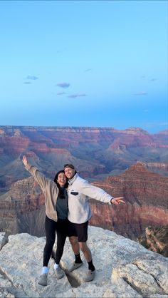 two people posing for a photo at the edge of a cliff in grand canyon national park