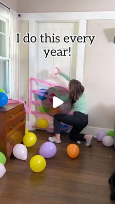 a woman is playing with balloons in the living room