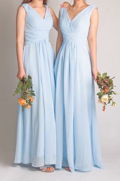 two bridesmaids in light blue dresses holding bouquets