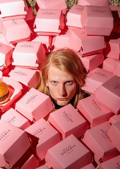 a woman is surrounded by pink cubes with donuts on them in the middle