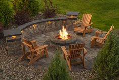 an outdoor fire pit with chairs around it