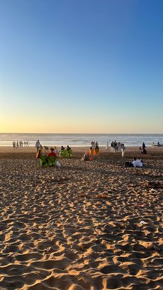 many people are on the beach at sunset