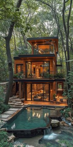 a house in the woods with a swimming pool and stairs leading up to it's second floor