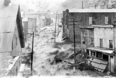 an old black and white photo of a city street that has been flooded with water