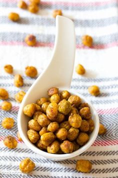 a white bowl filled with chickpeas on top of a checkered table cloth