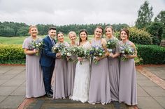 a group of people standing next to each other in front of a lush green field