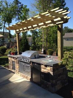 an outdoor kitchen with grill and sink