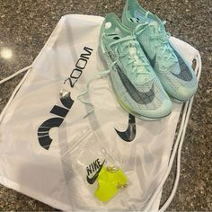 a pair of nike shoes sitting on top of a white bag next to a yellow object