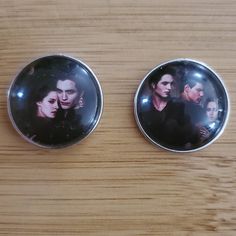 two buttons with the faces of actors on them sitting on a table next to each other