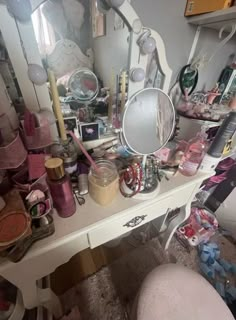 a vanity with lots of clutter on it and a mirror in the corner next to it