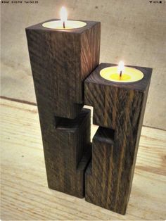 three wooden candles are stacked on top of each other in the shape of blocks with one candle lit