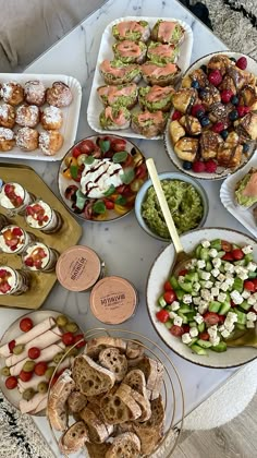 a table topped with lots of different types of foods and desserts on top of plates