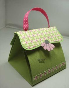 a small green bag with pink flowers on the front and bottom, sitting on a white surface