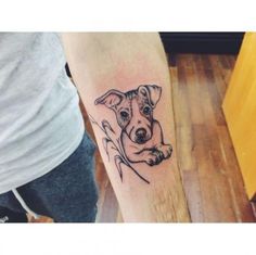 a small dog tattoo on the arm