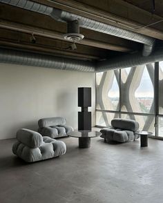 an empty room with two couches and a table in front of a large window