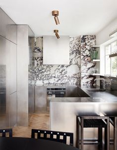 a kitchen with marble walls and stainless steel appliances