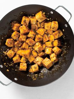 tofu is being cooked in a wok on the stove