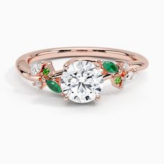 a rose gold engagement ring with green and white stones