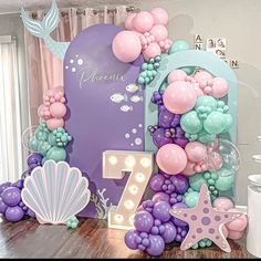 the table is decorated with balloons and other items for an ocean themed birthday party or baby's first birthday