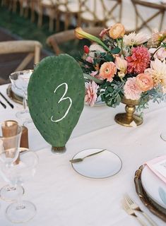 the table is set with flowers and place settings