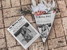 two newspaper pages laying on the ground next to flowers