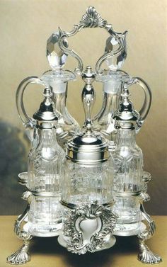 an ornate silver and glass tea set on a table