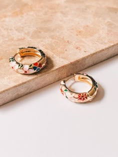 Give your look a timeless twist with these cloisonné flower hoops! Enameled in beautiful shades, they're the perfect accessory to bring a pop of color to your outfit. No matter what you pair them with, they'll be sure to make a statement! Dimensions : 0.75" diameter, 0.23" width Materials : Brass, Enamel, 18K Gold Plating CARE :It is suggested that you treat these with relative care. To maintain the pieces for years, please avoid wearing the jewelry in water, and remove while sleeping or exercis Gold Cleaner, Cool Piercings, Asian Bridal, Liquid Gold, Jewelry Lookbook, Enamel Flower, Green Enamel, Gold Enamel, Jewelry Inspo