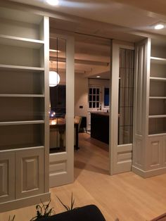 an empty living room with open doors leading to the kitchen