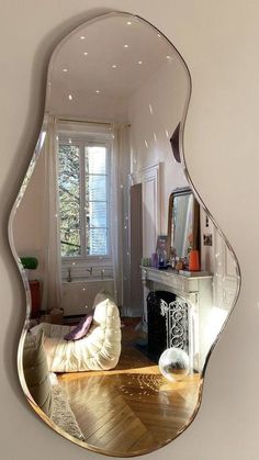 a mirror that is on the wall in front of a couch and table with a fireplace