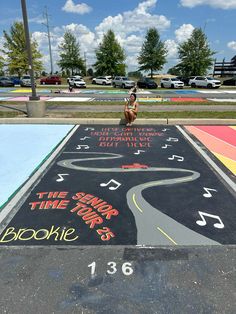 a dog is sitting on the side of a painted road with music notes and words