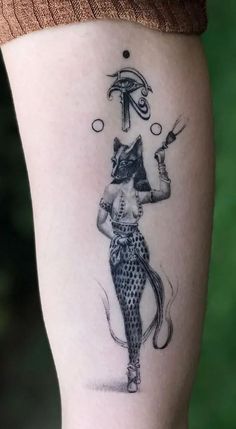 a woman's leg with a tattoo on it that has an image of a cat holding