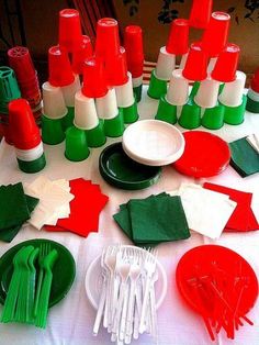 a table topped with lots of red and green items on top of a white table cloth