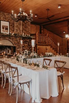 a dining room with tables and chairs set up for a formal function in front of a fireplace