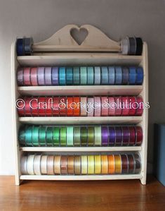 a wooden shelf filled with lots of different colored ribbons