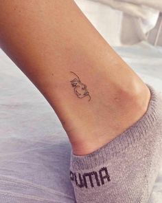 a woman's foot with a small tattoo on her ankle and the word mama written in black ink