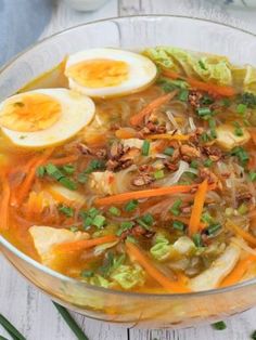 a glass bowl filled with soup and hard boiled eggs