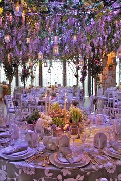 a table is set with purple flowers and candles