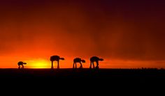 the silhouettes of three star wars vehicles against an orange and black sky at sunset